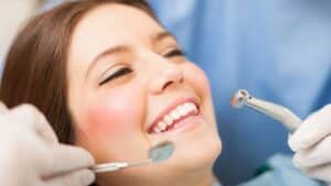 Patient smiling during orthodontist treatment in White Plains, NY with dental tools being used for professional care and smile improvement.